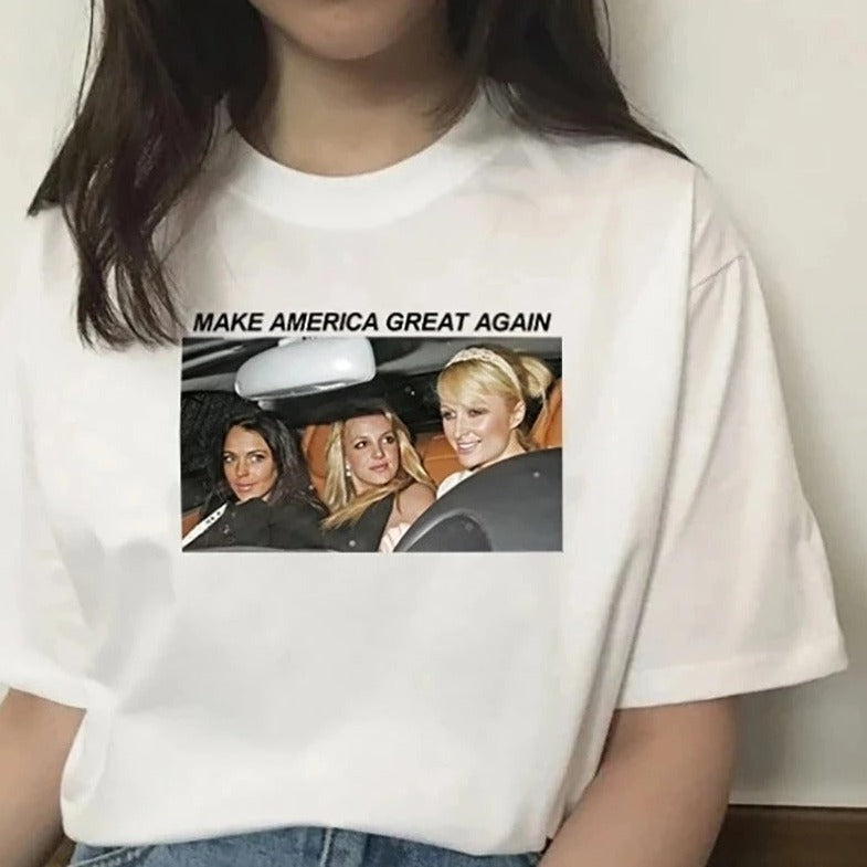 Weißes T-Shirt mit Aufdruck "Make America Great Again" und Bild von drei Frauen im Auto. Modetrend, Statement-Shirt, lässiger Stil.