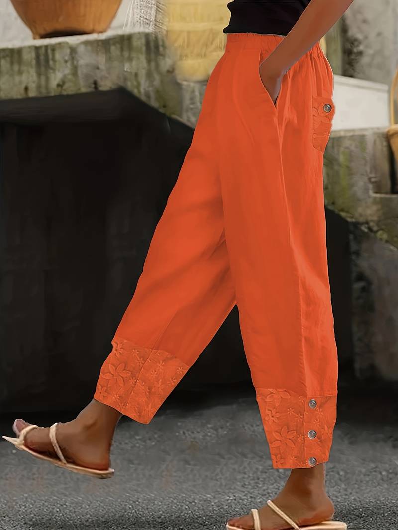Damenhose in leuchtendem Orange, lässiger Stil mit Knöpfen und floralen Details. Perfekt für Sommermode und Freizeitoutfits.