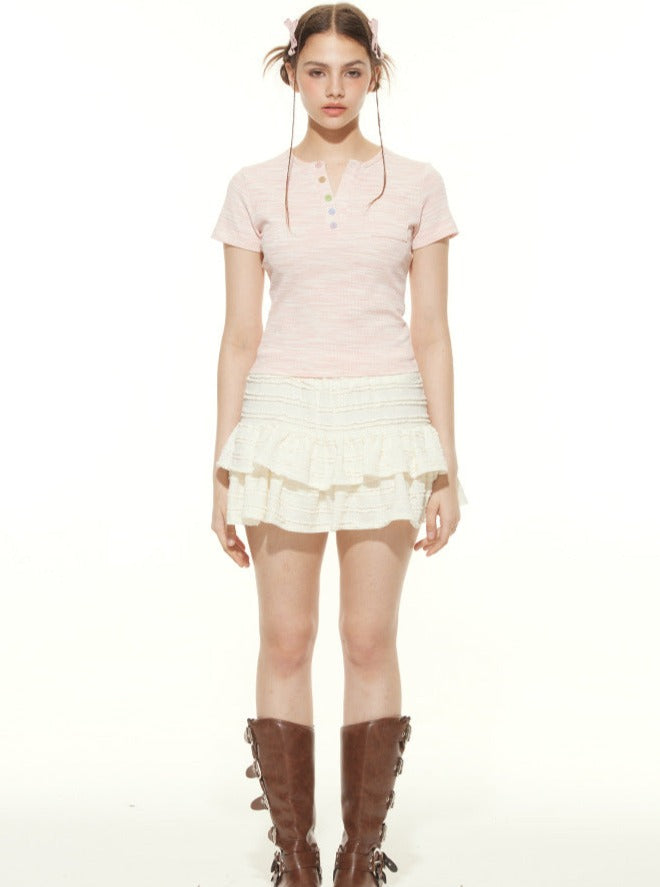 Junge Frau in rosa Poloshirt und weißem Rüschenrock, trägt braune Stiefel. Modetrend, lässiger Look, stilvolle Damenbekleidung.