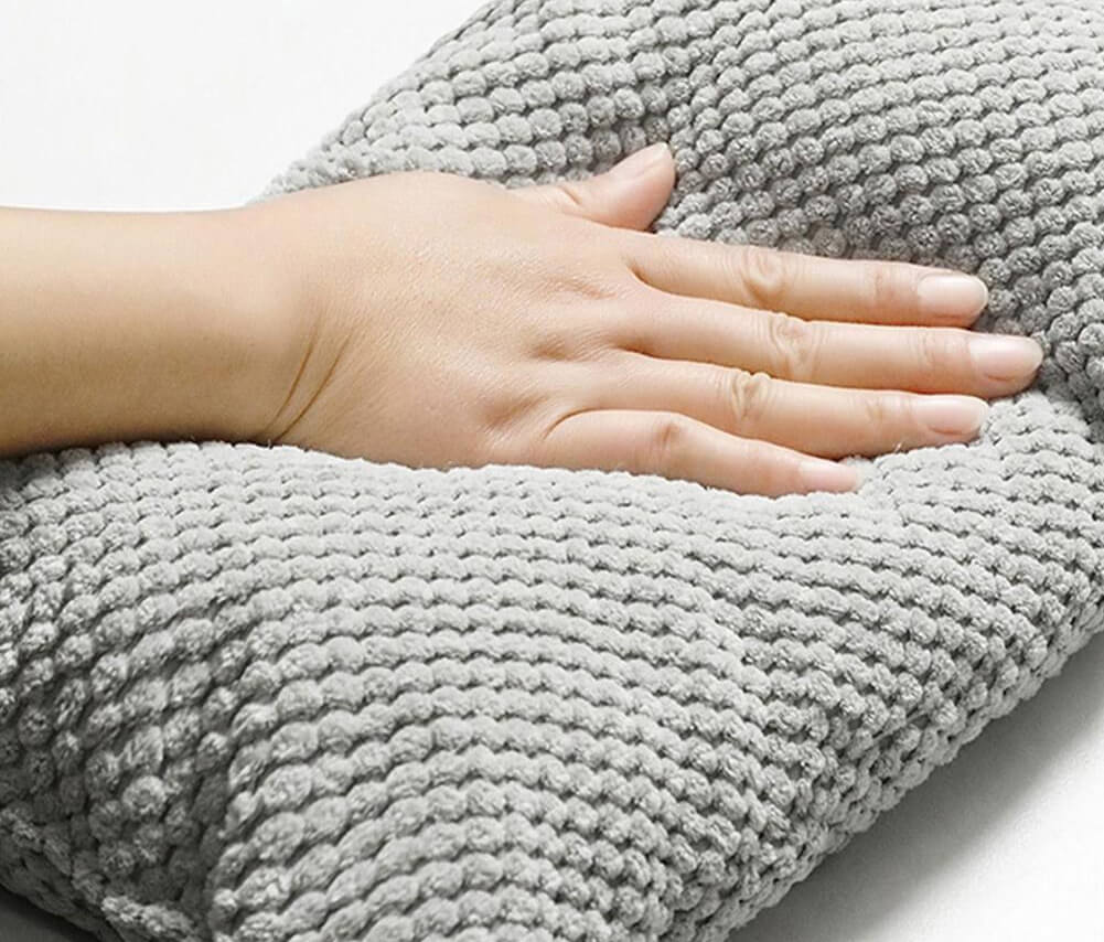 Graues, weiches Kissen mit strukturierter Oberfläche, ideal für Komfort und Entspannung. Perfekt für Sofa oder Bett. Hochwertige Heimtextilien.