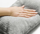 Graues, weiches Kissen mit strukturierter Oberfläche, ideal für Komfort und Entspannung. Perfekt für Sofa oder Bett. Hochwertige Heimtextilien.