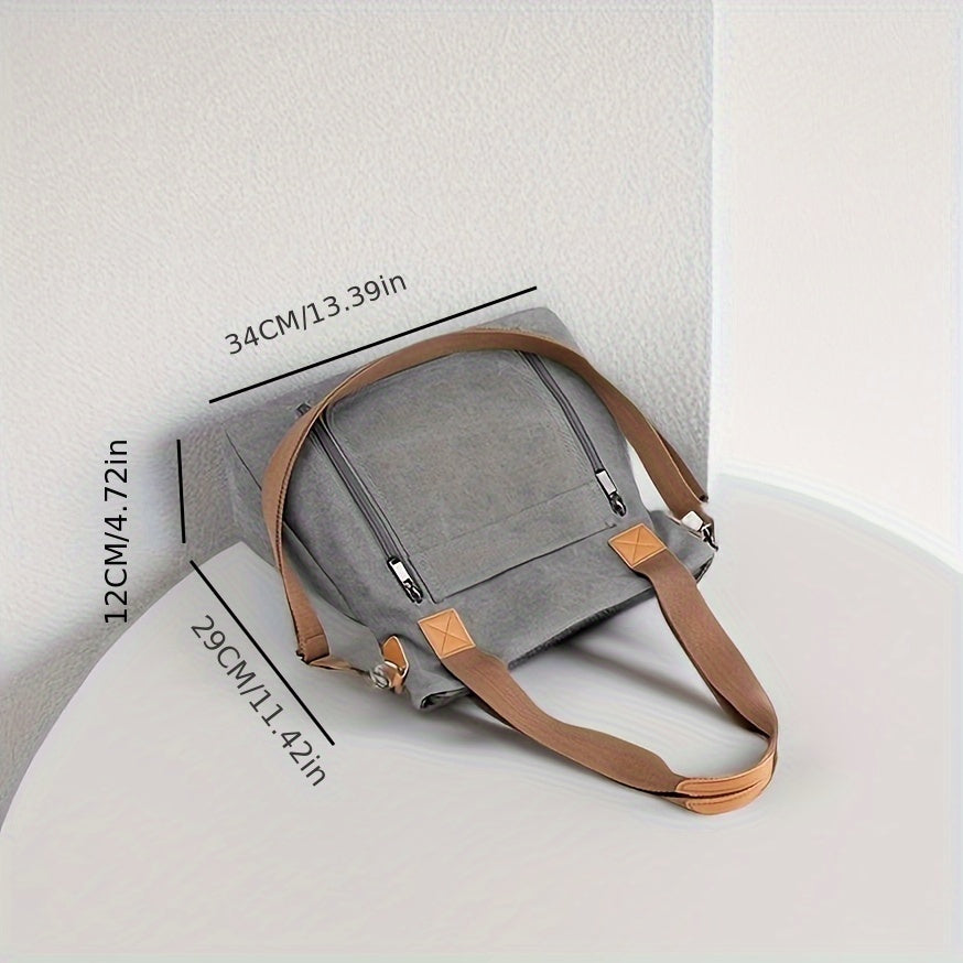 Graue Canvas-Tasche mit braunen Griffen, ideal für Alltag und Reisen. Stilvoll, geräumig, langlebig. Maße: 34x29x12 cm. Perfekt für Damen.