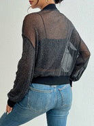 Damenmode: Schwarze, transparente Glitzerjacke kombiniert mit blauen Jeans. Trendige, elegante Oberbekleidung für stilvolle Outfits.