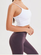 Damen-Sportbekleidung: Weißes Tanktop und lila Leggings. Perfekt für Fitness, Yoga und Workout. Bequeme und stilvolle Sportmode.