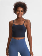 Damen-Sportbekleidung: Schwarzes Tanktop und blaue Leggings, ideal für Fitness und Yoga. Bequeme, atmungsaktive Materialien für aktive Frauen.