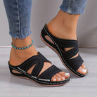 Schwarze Damen-Sandalen mit Keilabsatz, offenem Zehenbereich und dekorativen Ausschnitten, ideal für Sommermode und Freizeitoutfits.