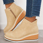 Beige Keilabsatz-Stiefeletten aus Lederimitat, kombiniert mit blauen Jeans. Modische Damen-Schuhe, ideal für Herbst-Outfits und lässigen Stil.