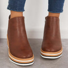 Damenstiefeletten aus braunem Leder mit weißer Sohle, modisch und bequem, ideal für Herbstmode. Perfekt kombinierbar mit Jeans.