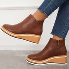 Damen-Stiefeletten aus braunem Leder mit Keilabsatz, Reißverschluss und sportlichem Design. Perfekt für Herbstmode und bequemen Alltagsstil.