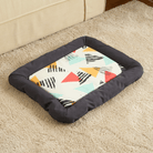 Buntes Hundebett mit geometrischem Muster, rechteckig, weiche Ränder, auf Teppich.