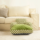 Grün-weiß kariertes Haustierbett vor beigem Sofa, bequemes Design, Wohnzimmer-Dekoration.