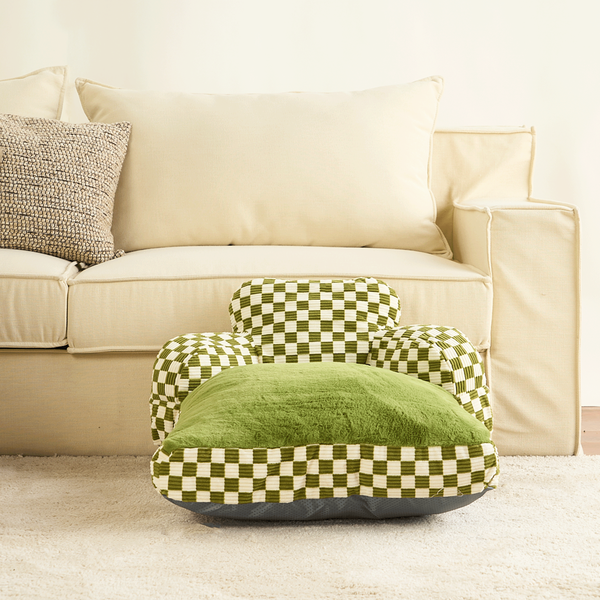 Grün-weiß kariertes Haustierbett vor beigem Sofa, bequemes Design, Wohnzimmer-Dekoration.