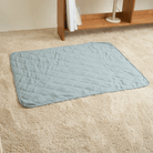 Hellblaue Kühlmatte für Haustiere auf beigem Teppich, ideal für Hunde und Katzen im Sommer.