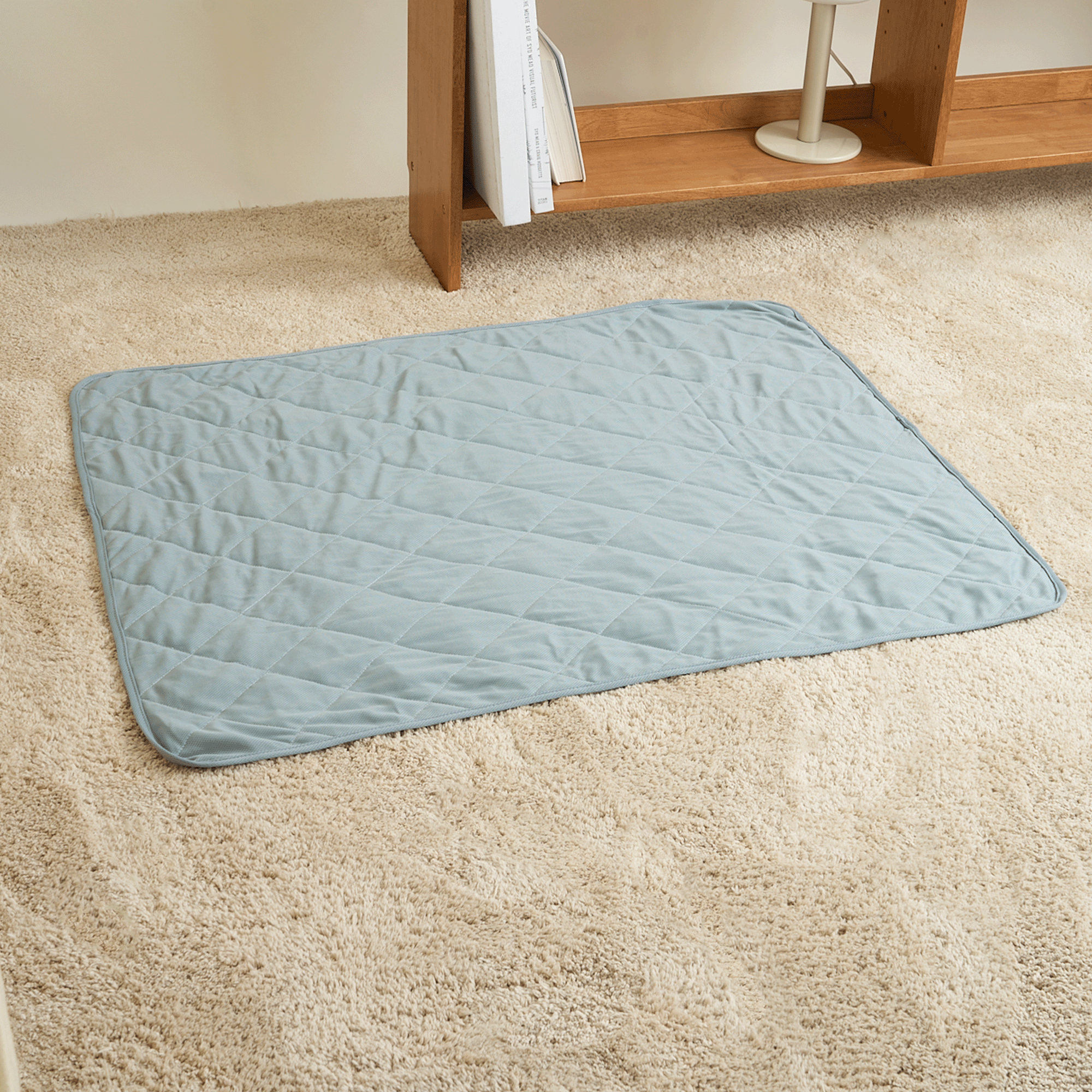 Hellblaue Kühlmatte für Haustiere auf beigem Teppich, ideal für Hunde und Katzen im Sommer.