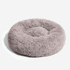 Rundes, flauschiges Hundebett aus grauem Plüsch, gemütlich und weich für Haustiere.