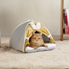 Katzenbett Zeltform, beige und grau, mit Ohren, gemütlich, auf Teppich, für Katzenruhe.