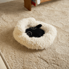 Katzenbett aus Plüsch in Weiß, rund, gemütlich, für Haustiere, auf Teppichboden.