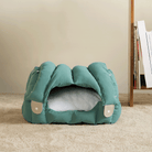 Grünes Katzenbett aus Stoff, gemütlich, modern, auf Teppich, ideal für Haustiere.