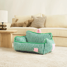Grünes gestreiftes Haustiersofa aus Plüsch auf Teppich, gemütliches Design für Hunde und Katzen.