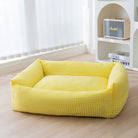 Gelbes, rechteckiges, waschbares Hundebett, atmungsaktiv, kariertes Design, auf Holzboden.