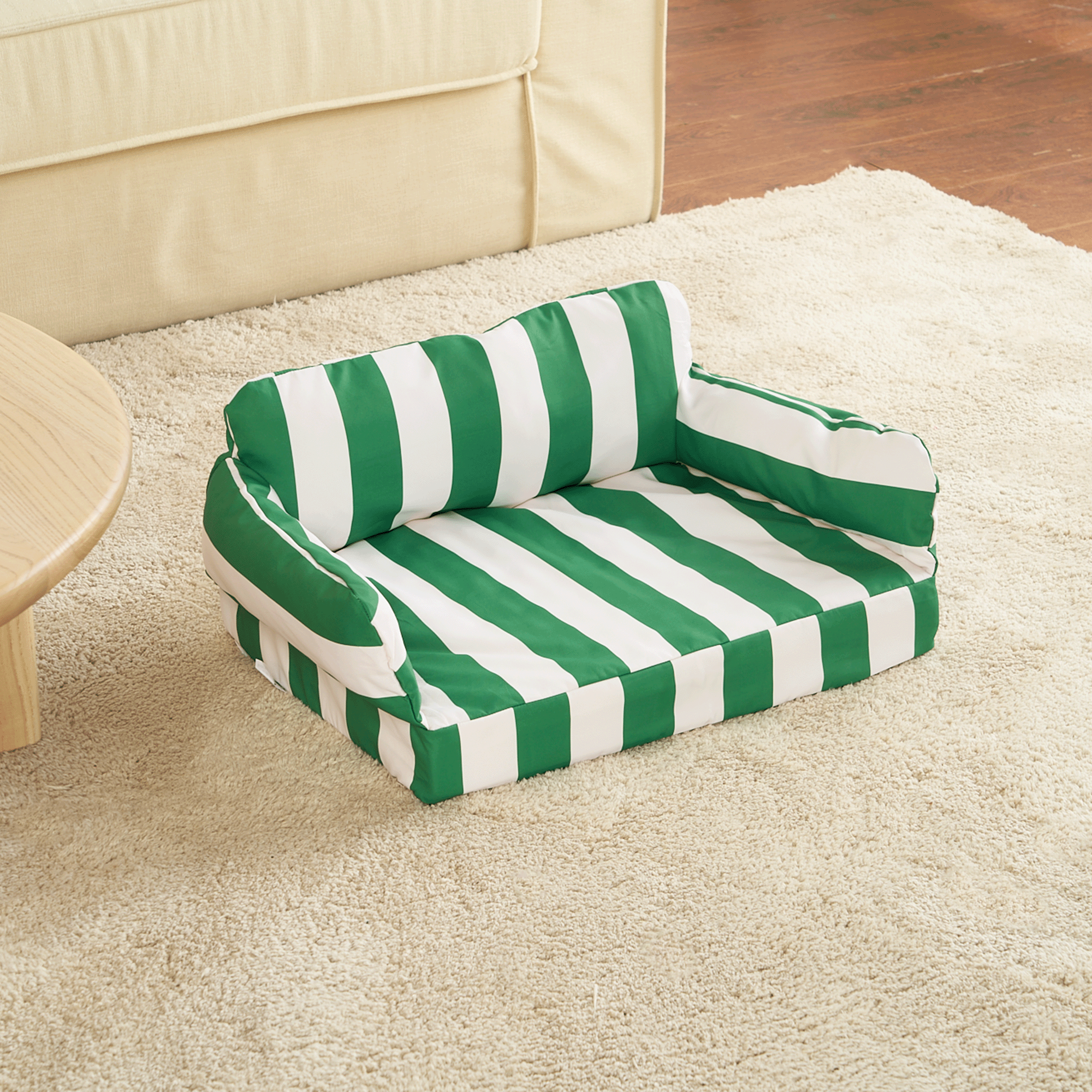 Grün-weiß gestreiftes Haustiersofa auf Teppich, bequemes Hundebett, modernes Design.