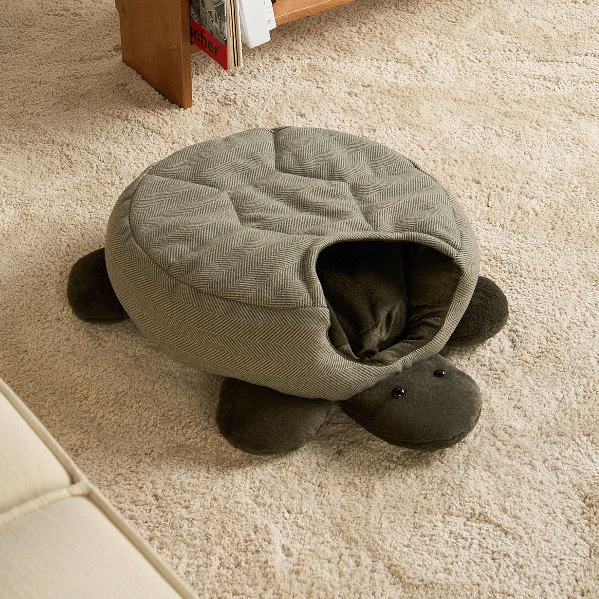 Schildkrötenförmiges Haustierbett aus Stoff auf Teppichboden, gemütlich und stilvoll.
