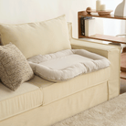 Wasserdichtes orthopädisches Haustierbett, beige, auf cremefarbenem Sofa, modernes Design.