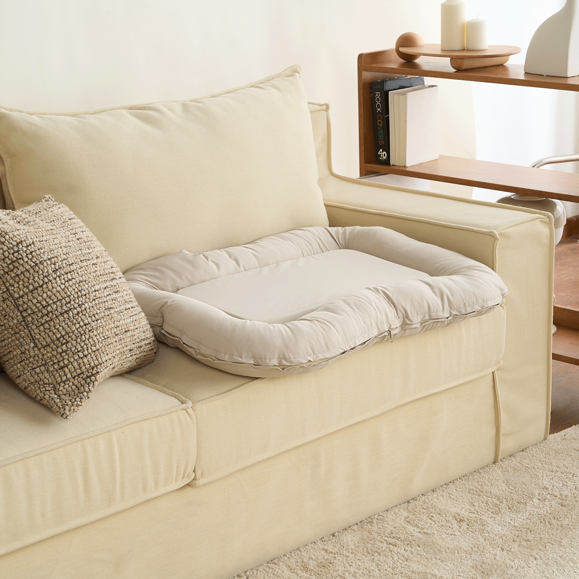 Wasserdichtes orthopädisches Haustierbett, beige, auf cremefarbenem Sofa, modernes Design.