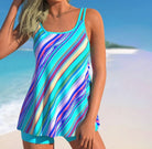 Bunter Tankini mit Streifenmuster am Strand, ideal für Sommermode und Bademode. Perfekt für Strandurlaub und sonnige Tage am Meer.