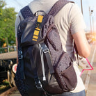 Person mit gepunktetem Rucksack am Bahnhof, Reisender, Outdoor, Freizeit, schwarz, gelber Gurt.