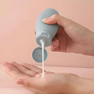 Hand drückt weiße Lotion aus grauer Flasche, Hautpflege, Feuchtigkeitscreme, Kosmetikprodukt.