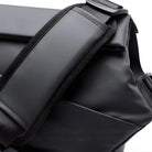 Schwarzer Rucksack aus wasserdichtem Material mit verstellbaren Trägern.