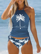 Frau im blauen Tankini mit Palmenmotiv am Strand, Badeanzug, Sommermode, Strandbekleidung.