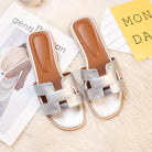 Silberne Damen-Sandalen mit offenem Zehenbereich auf flauschigem Teppich, modisch und bequem, ideal für Sommer und Freizeit.