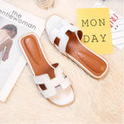 Weiße Damen-Sandalen auf flauschigem Teppich, modisch und bequem. Perfekt für den Sommer. Elegante Schuhe für Freizeit und Alltag.