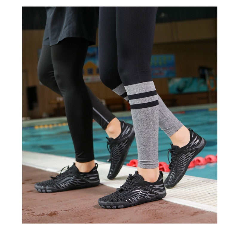 Zwei Personen tragen schwarze Barfußschuhe am Poolrand. Ideal für Fitness, Yoga und Wassersport. Leicht, flexibel und rutschfest.