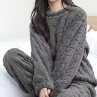 Gemütlicher grauer Fleece-Pyjama für Damen, ideal für kalte Nächte. Weiches Material, modisches Design, perfekte Winterbekleidung.