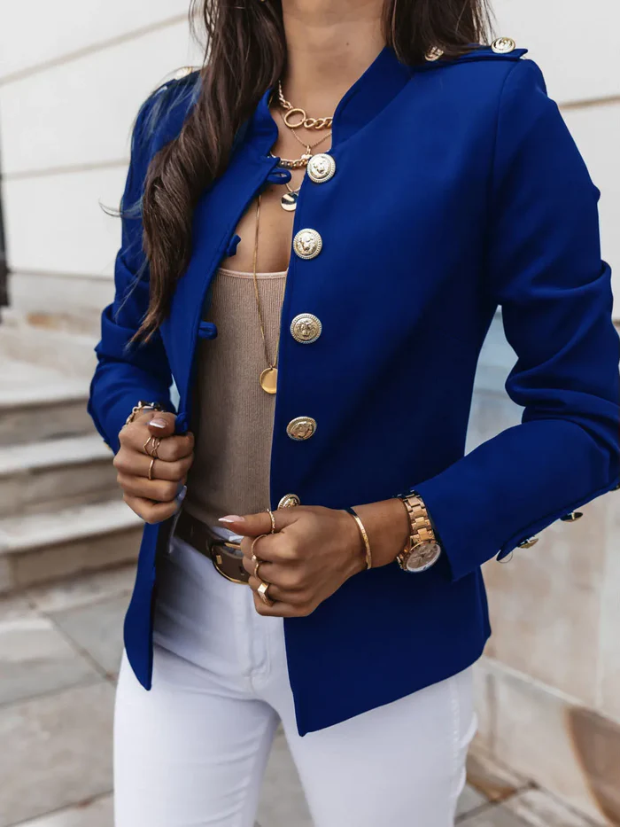 Frau in eleganter blauer Jacke mit goldenen Knöpfen, kombiniert mit weißer Hose. Modetrend, Damenmode, stilvolle Outfits, Herbstmode.