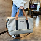 Beige Reisetasche mit braunen Griffen, ideal für Reisen, geräumig, stilvoll, Unisex-Design.