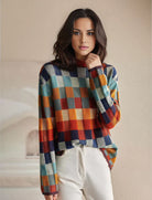 Frau in kariertem Pullover, bunte Herbstmode, lässiger Look, Damenbekleidung, modischer Strick, stilvolle Freizeitkleidung, trendige Outfits.