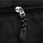Schwarzer Reißverschluss mit gelb-schwarzem Kordelzug an Tasche, Nahaufnahme.