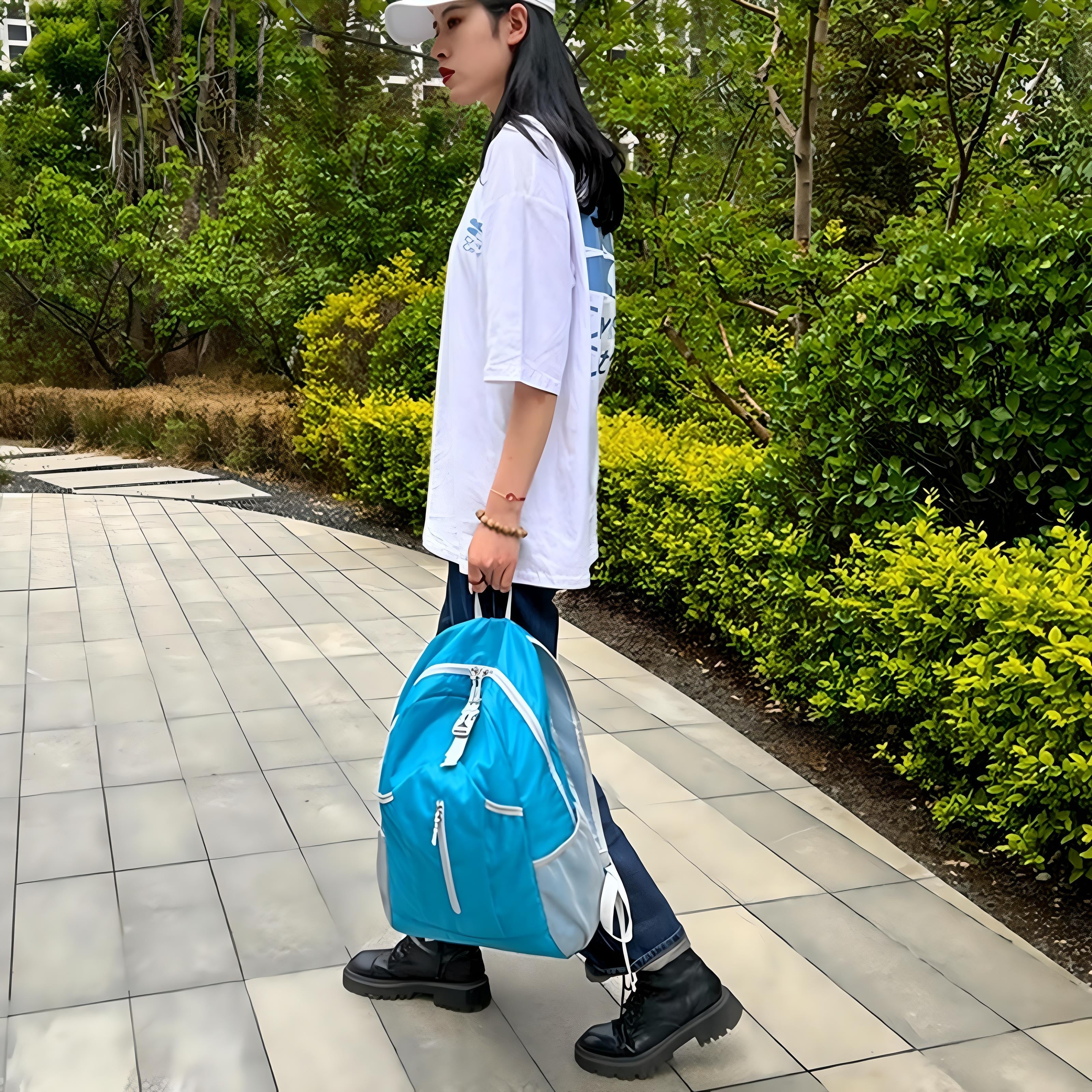 Frau mit blauem Rucksack, weißem T-Shirt und schwarzer Hose spaziert im Park.