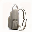 Beiger Rucksack aus Leder, seitliche Ansicht, mit verstellbaren Trägern und Reißverschlusstaschen.