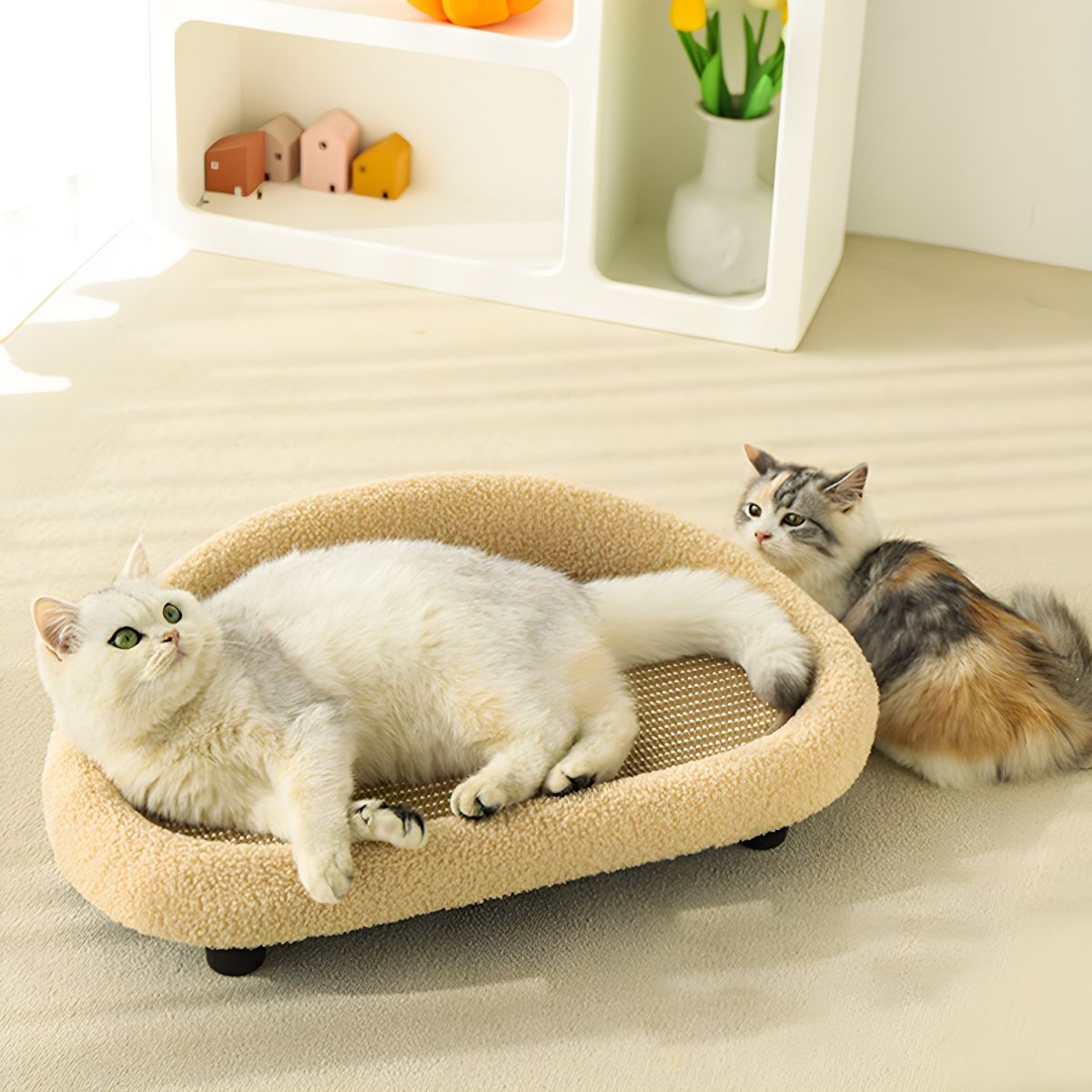 Katzenbett aus Plüsch in Beige mit Kratzfläche, zwei Katzen, modernes Design, Wohnzimmer.