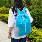 Frau mit blauem Rucksack im Park, Freizeit, Outdoor, Mode, Rückansicht, Natur, Spaziergang.