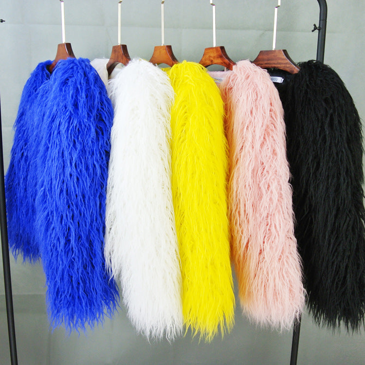Bunte Kunstpelzmäntel in Blau, Weiß, Gelb, Rosa und Schwarz auf Kleiderbügeln. Modetrend, stilvolle Oberbekleidung, luxuriöse Textur.
