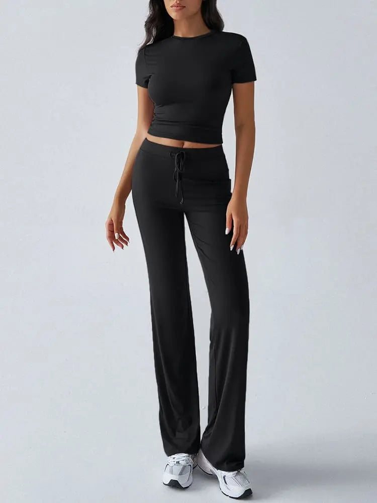 Damen-Sportanzug in Schwarz, bestehend aus kurzärmligem Oberteil und Jogginghose. Ideal für Fitness, Yoga und Freizeit. Bequem und stilvoll.