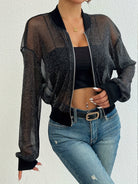 Damenmode: Transparente schwarze Glitzer-Bomberjacke, kombiniert mit schwarzem Top und Jeans. Trendige Streetwear für stilvolle Outfits.