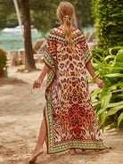 Frau im eleganten Leopardenmuster-Kaftan am Strand, Sommermode, Boho-Stil, Urlaubskleidung, tropische Kulisse, entspannter Look.