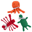 Drei bunte, gestrickte Tier-Spielzeuge: orange Oktopus, rote Krabbe, grüne Schildkröte.